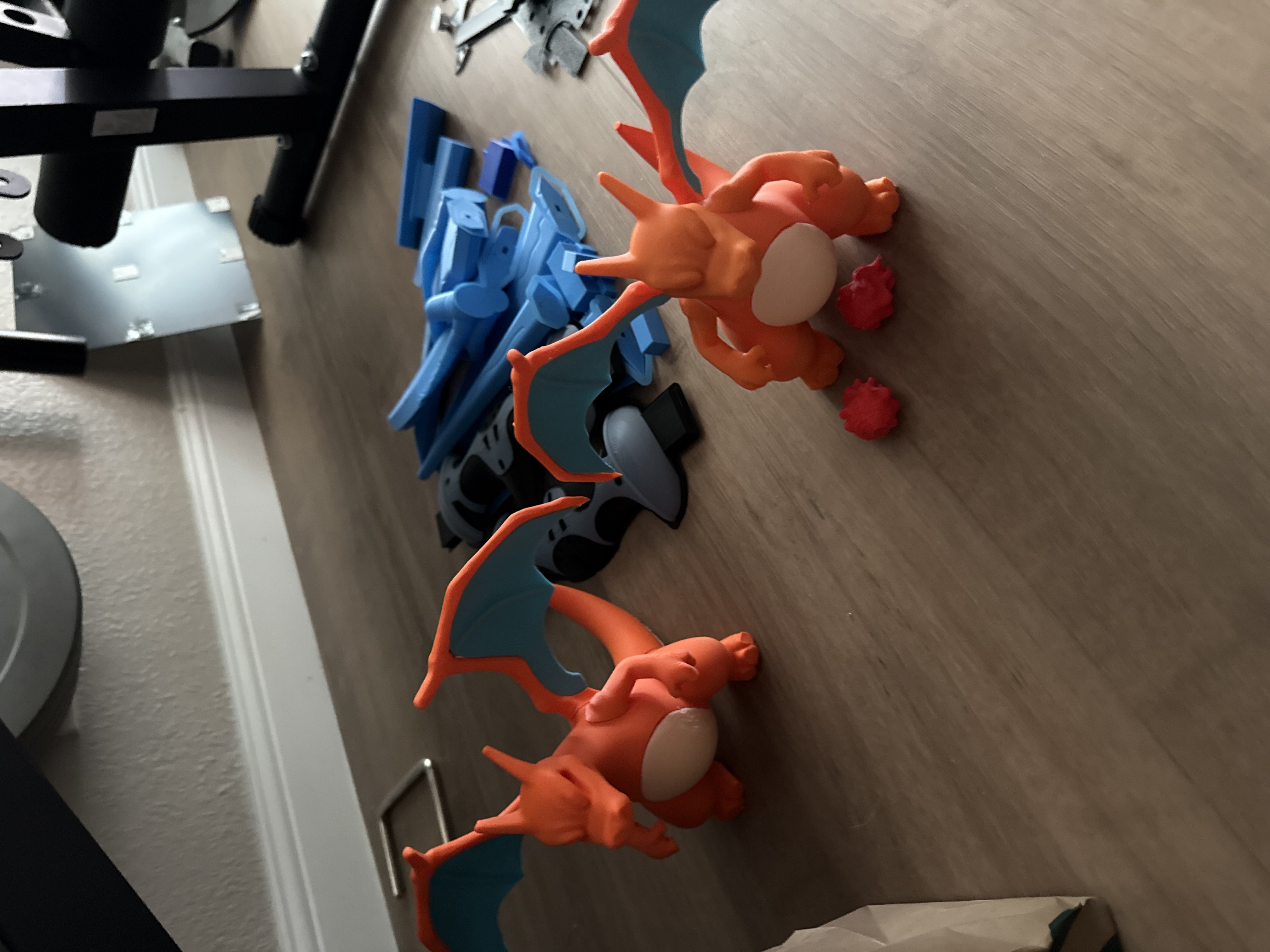 Two Charizard 3D printed figures in orange with teal wings
