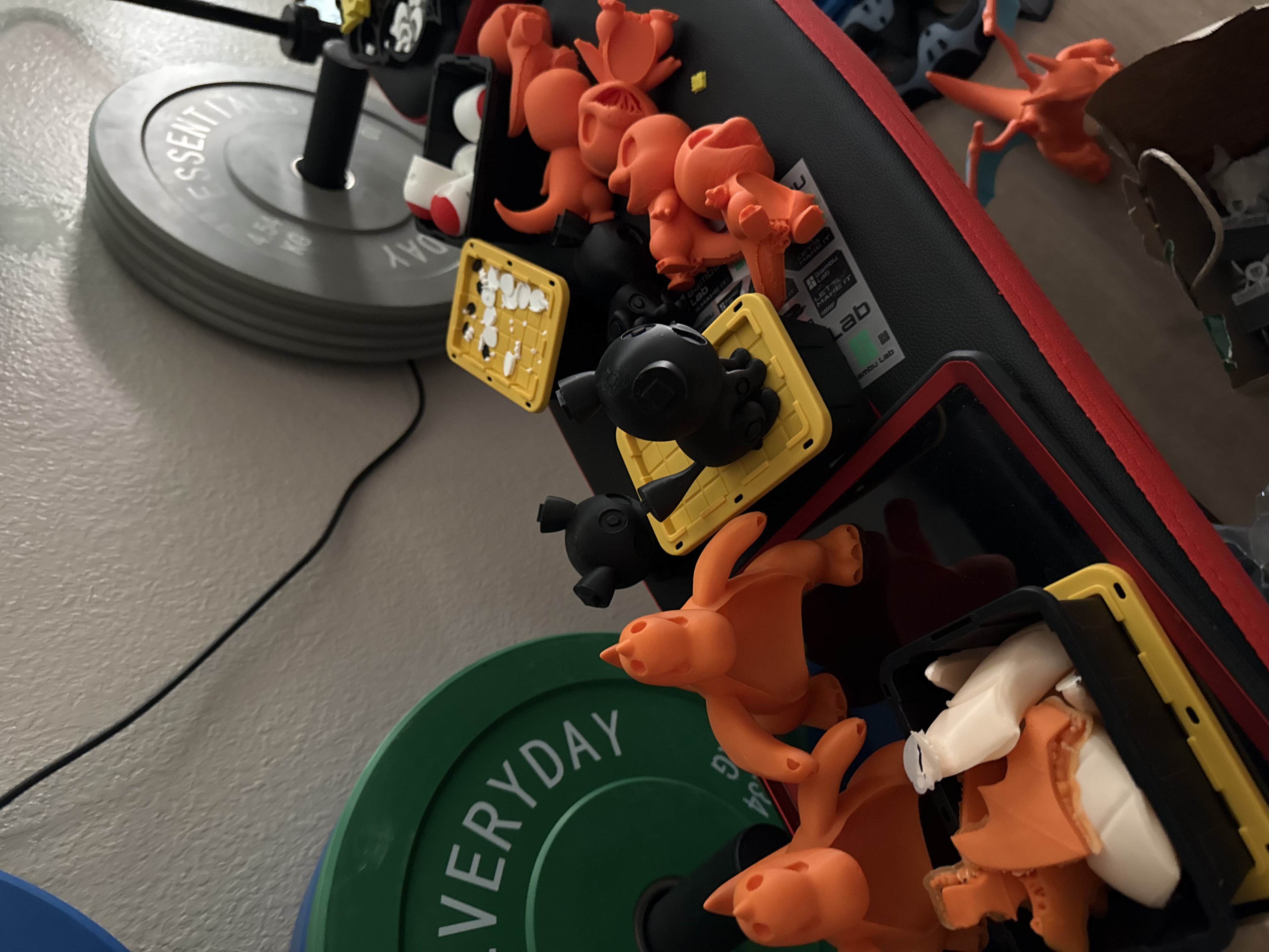 Multiple Charmander figures and other 3D prints on a shelf